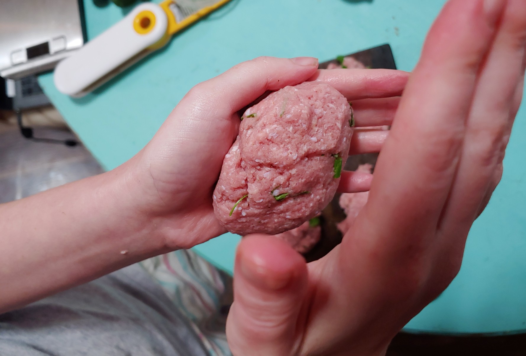 Turkey burger mix being slapped between hands to form patties