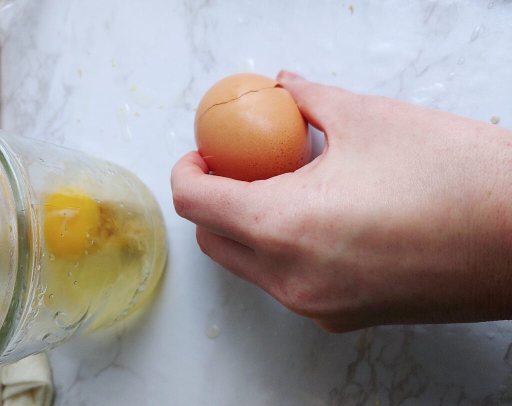 Crack the egg onto a flat surface