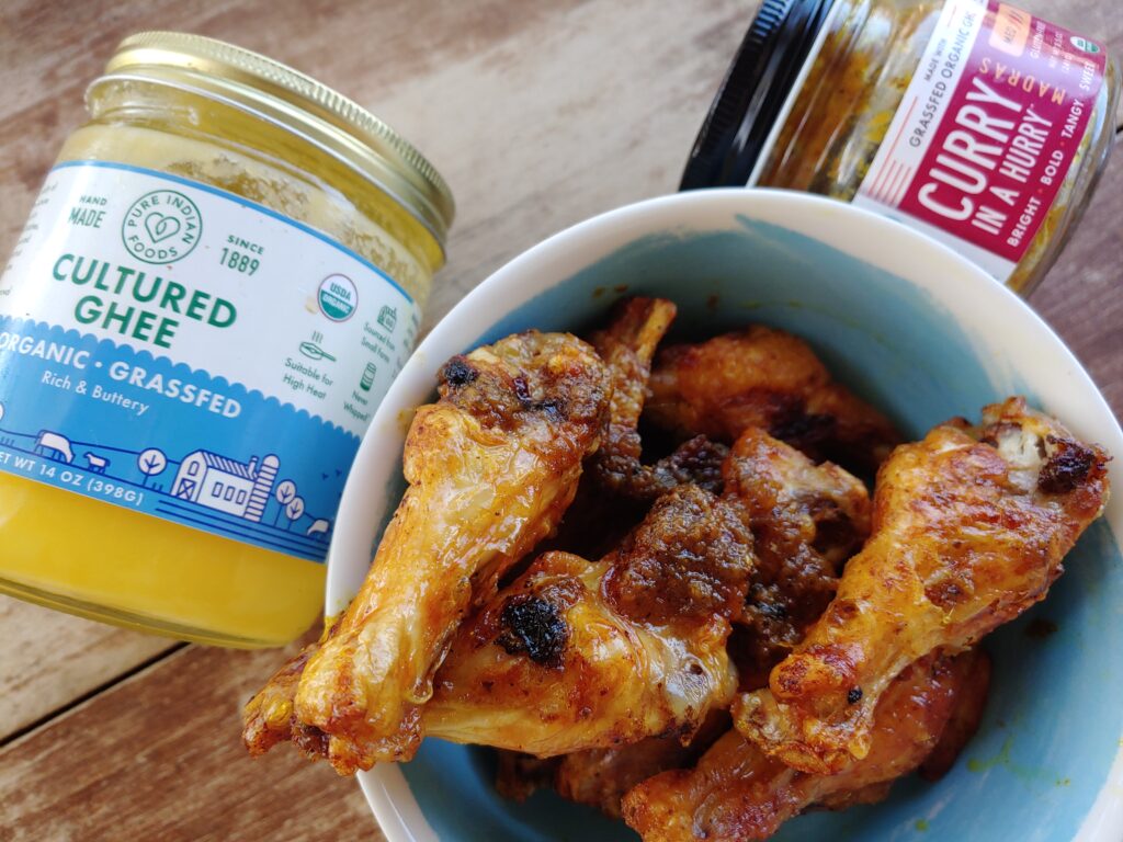 air fryer curry chicken wings in bowl with curry in a hurry and pure indian foods ghee made in the ninja foodi